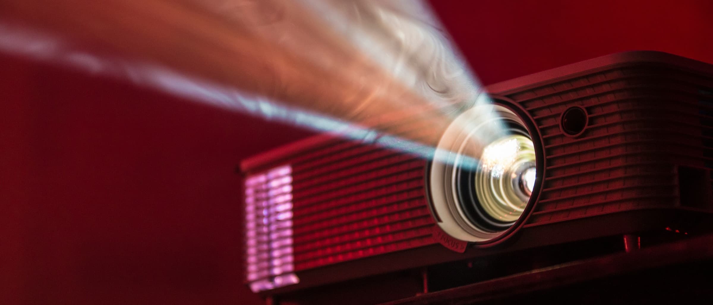 Projector beam cutting through a dark red-lit room